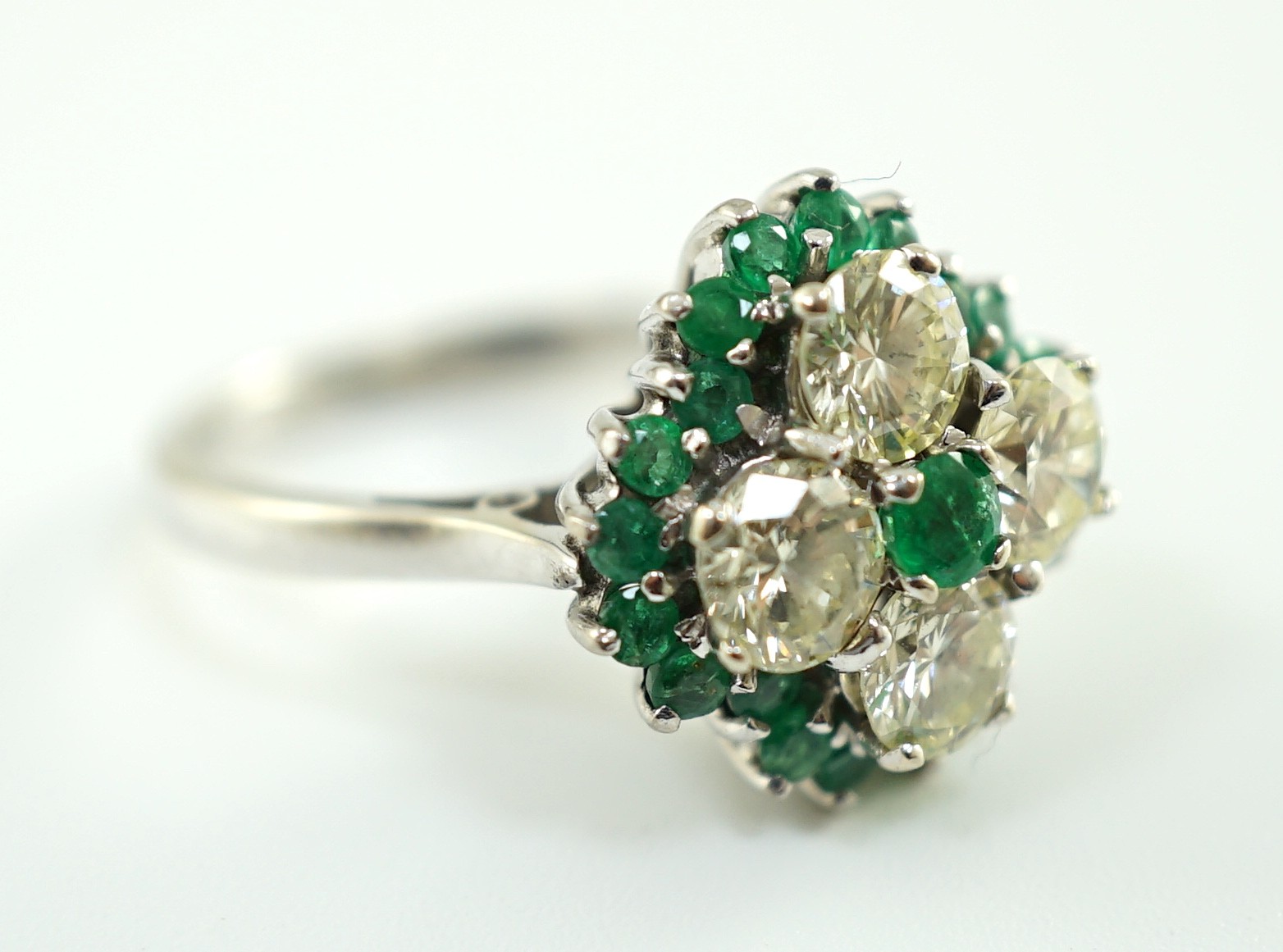 An 18ct white gold, emerald and diamond cluster set dress ring